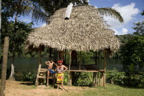 Native Embera Indians outside  grass hut in traditional dress.American Central America Classic Classical Hispanic Historical Immature Latin America Latino Older Panamanian
