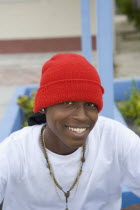 Head and shoulders portrait of a young smiling Belizean man wearing red cap white t-shirt and a necklace.SummerHolidaysVacationRelaxSunTropicalTourismHotHeatStyleHappyTeethSmileExpressio...