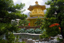 Wong Tai Sin Lian Gardens  Diamond Hill. Behind trees view of a Tang Dynasty Style Chinese Golden Temple With Red Wooden Bridge Known As Pavilion Of Absolute Perfection Lotus Pond At Nan Lian Garden....