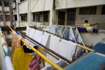 Tsim Sha Tsui. Nathan Road. Woman hanging clothes to dry using special sticks at the balcony of an old building.Block of flatsResidenciesBuildingStructureArchitectureAir conditionAsiaCultureL...