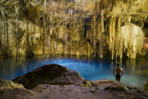 Cenote Dzitnup known as well as Xkeken with many stalagmites  natural blue water pool and a man ready to dive.MayaMayanToltecHistoryVacationHolidaysTravelAncientExoticFolkloreHuman Heritage...