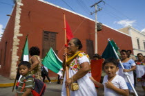 Plaza Principal. Mexican women and kids participating at a local fiesta  holding Mexicos flags and red color flag.ReligionWorshiperParadeChristianityEventBeliefSpiritualTraditionCultureCeleb...