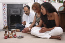 Hindu family at prayer in their home.UKEnglandReligionReligiousHinduHinduismWorshipPrayerFamilyEuropeEuropean British Isles Great Britain Immature Northern Europe Religion Religious Hinduis...