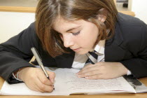 Girl in uniform writing in exercise book.StudentChildFemaleGirlLearningEducationEuropeanEuropeanGreat BritainKingdomUnitedEnglandUKWritingWrittenPenpencilJotter British Isles Childre...