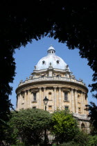The Radcliffe Camera library building  seen through arch of foliage.Oxford  Radcliffe Camera  UK  architecture  University Oxfordshire  England  English  Great Britain  colleges  Oxbridge  building...