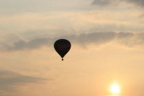 A hot air balloon in the evening sky.hot  air  balloon  evening  sky  floating  flying  sunset  sun  setting  picturesque  helium  travelling  high  clouds Blue Clouds Cloud Sky European Great Britai...