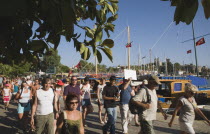 Tourist group being led by guide along harbour front in afternoon sun.Turkish Aegean coastmediterraneanresortformerly HalicarnassusHalikarnasregion of CariaDorian Greek occupiedsunsunshineSu...