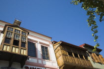 Part view of painted facades of Ottoman era wooden houses against blue sky. Fethiyeformerly Telmessosformerly modern Greek MakriAegeanTurkish rivieraLycianLyciaOttomansummerseasonsunholidaycruiseblue skyshelterresortCultural Cultures Destination Destinations European History Historic Middle East Order Fellowship Guild Club Turkiye Western Asia