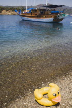 Gulet pleasure boat moored in clear shallow water off Gemiler Island also known as St Nicholas Island with childs inflatable yellow float in foreground.Fethiyeformerly Telmessosformerly modern Gree...