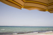 Tingaki beach on North East coast facing Turkey and Bodrum area from the shade of a sunbed and parasol.Greek Islands Tingaki Resort Summer Clear Blue Sky early seasonDestination Destinations Ellada E...