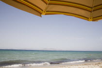 Tingaki beach on North East coast facing Turkey and Bodrum area from the shade of a sunbed and parasol.Greek Islands Tingaki Resort Summer Clear Blue Sky early seasonDestination Destinations Ellada E...