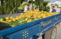 Man with blue trailer full of green and yellow melons.fruitTurkishAegeancoastresortSummersunshineearly Summer seasonholidaydestinationdestinations ElladaEuropeanSouthern Europe Destinatio...