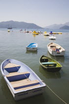 Marmaris on the Turkish Riviera in early Summer season.  Private rowing boats moored on beach in early morning sun with pedalos and yachts beyondcoastcoastalflatcalmstill Destination Destinations...