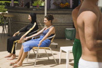 Turkish woman on left  dressed in black Burkini  a head to ankle swimsuit preferred by traditional Muslim women in Turkey in Summer with young Turkish woman dressed in Western style sitting beside her...