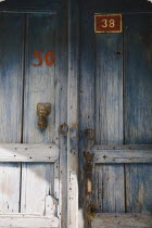 Ottoman era wooden door with faded remnants of blue paint and locks with hand shaped door-knock and house numbers in old town.formerly Greek Physkos in Caria once host to AlexandeTurkish Rivieracoa...