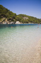 Olu Deniz.  Clear aquamarine water in lagoon with tourists swimming on perfect clear early Summer afternoon.Turkish rivieraAegeancoastcoastalOludenizseashorecalmclearshallowazurebrightsun...