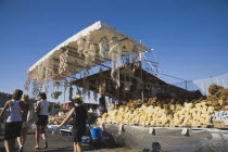 Rhodes Town  Mandraki Harbour.  Tourist souvenir stall on harbourside selling sponges from nearby Symi and seashell crafts in late afternoon sunshine.AegeancoastcoastalWorld Heritage Siteformer O...