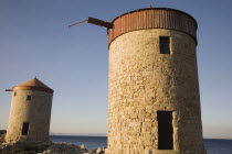 Rhodes Town  Mandraki Harbour.  Old  circular stone windmills on pier in clear  late afternoon sun.AegeancoastcoastalWorld Heritage Siteformer Ottoman territoryOld townlocation for Guns of Nava...