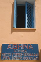 Rhodes Old Town.  Detail of typical Greek Island house with ochre coloured walls and blue painted window shutters with painted sign for Pita  Gyros and Souvlaki the essential Greek fast food kebab. A...