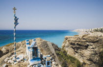 Memorial shrine and cross on headland above Ixia beach resort looking East towards Rhodes Town with clear  aquamarine sea beyond. Aegeancoastcoastalformer Ottoman territorylocation for Guns of Na...