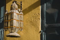 Rhodes Town.  Decorative lantern hanging outside  yellow painted exterior of house in the Old Town in afternoon sun.AegeancoastcoastalFormer Ottoman territoryearlySummer seasonlocation of Guns...