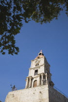 Rhodes Town.  Ottoman Turkish clocktower  the highest viewpoint in Rhodes Old Town against clear blue sky of late afternoon in early summer  part framed by tree branches.AegeancoastcoastalFormer O...