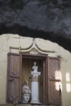 Detail of window in wall of building with open wooden shutters displaying statutary; head of a soldier and torso of female figure on column.AegeancoastcoastalFormer Ottoman territoryearlySummer...
