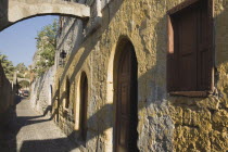 Traditional Greek yellow and white painted house in Rhodes Old Town with preserved medieval arches. AegeancoastcoastalFormer Ottoman territoryearlySummer seasonlocation of Guns of Navaronepack...