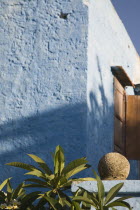 Typical Greek pale blue painted house with wooden shutters  with medieval canonball from Knights of St John era in the foreground.AegeancoastcoastalFormer Ottoman territoryearlySummer seasonloc...