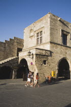 Old Town.  Argykastron Square in late afternoon sun.  Tourists walking past former Tribune of Commerce  square  stone building with steps and arched entrances.Aegeancoast  coastalFormer Ottoman ter...