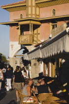 Exterior of restored Ottoman era Mosque on Odos Sokratous Street  the main tourist shopping area in Rhodes Old Town with people seated at outside tables of cafe in foreground.AegeanGreekByzantineR...