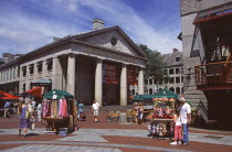 Quincy Market exterior with stalls selling scarves and puppet toys.TravelTourismHolidayVacationExploreRecreationLeisureSightseeingTouristAttractionTourDestinationTripJourneyPastimePlea...