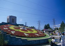 CANADA, Ontario, Niagara, Floral Clock at Hydro Electric Power Station Floral Cloak with tourists underneath the power lines.