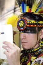 International Peace Pow Wow. Cree man from Saddle Lake Reserve in northern Alberta applying face paintIndigenous American Canadian Indegent Male Men Guy North America One individual Solo Lone Solitar...