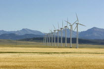 The latest generation of Vestas wind turbines with a wheat field in the foreground and the Rocky Mountains in the background.American Canadian North America Northern Blue Cereal Grain Crop Ecology En...