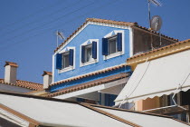 Pythagorio.  Detail of holiday apartments with tiled rooftops  window shutters and sun awnings overlooking bay.AegeanGreek IslandsPithagorion Pythagorioncoast coastalseaSummerpackageholidayre...