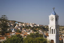 Pythagorio.  Metamorfosis Sotiros Greek orthodox Church.  Blue and white clock and bell tower with houses stretched across hillside beyond.AegeanGreek IslandsPithagorion Pythagorioncoast coastals...