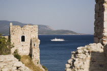 Pythagorio.  Logothetes Castle ruins with regional Greek ferry crossing the Northern Aegean / Dodecanese region framed between castle ramparts.  The coast of Turkey  five kilometres away behind.Lykou...