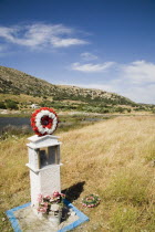 Pythagorio.  Memorial family shrine with wreath and flower tributes on roadside.North Eastern AegeanGreek IslandsPithagorion Pythagorioncoast coastalseaSummerpackageholidayresortvacationtri...
