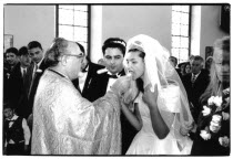 Traditional Greek Wedding. Priest offering Bride cake or bread during ceremony.Religion Religious Christianity Christians European Classic Classical Marriage Marrying Espousing Hymeneals Nuptials