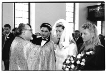 Traditional Greek Wedding. Priest offering Bride wine during ceremony.Marriage Marrying Espousing Hymeneals Nuptials Vino Vin Alcohol Grape Winery Drink Religion Religious Christianity Christians Cla...