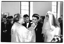 Traditional Greek Wedding. Priest offering Groom bread or cake during ceremony.Christianity Christians Classic Classical European  Marriage Marrying Espousing Hymeneals Nuptials Religion Religion Rel...
