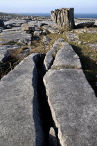 Limestone pavements and grykes leading to a single rock with the Atlantic behind.Eire European Irish Northern Europe Republic Ireland Poblacht na hEireann Blue Gray Karst Sedimentary Rock One indivi...