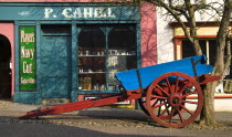 The Village Street denotes village life in 19th century Ireland Blue and Red wooden cart outside P. Cahill shopfront.Eire European Irish Northern Europe Republic Ireland Poblacht na hEireann History...