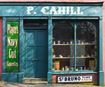 The Village Street denotes village life in 19th century Ireland Blue and Red wooden cart outside P. Cahill shopfront.TobacconistTobaccoStoreEire European Irish Northern Europe Republic Ireland Pobl...