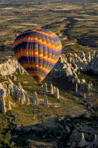 Turkey, Cappadocia, Goreme, Hot air balloons in flight over landscape, Hot air balloon glides over rock columns in Love Valley.