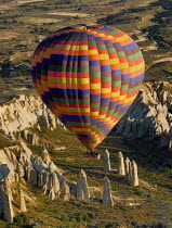 Turkey, Cappadocia, Goreme, Hot air balloons in flight over landscape, Hot air balloon glides over rock columns in Love Valley.