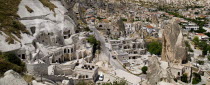 Turkey, Cappadocia, Goreme, Cave hotel with a section of the town and its minaret.