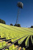 Germany, Bavaria, Munich, Olympic Stadium - The colourful green seats in the stadium with floodlights behind.