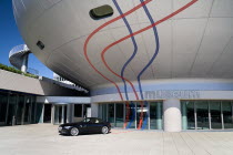Germany, Bavaria, Munich, BMW Headquarters, The BMW Museum, Entrance with car outside.